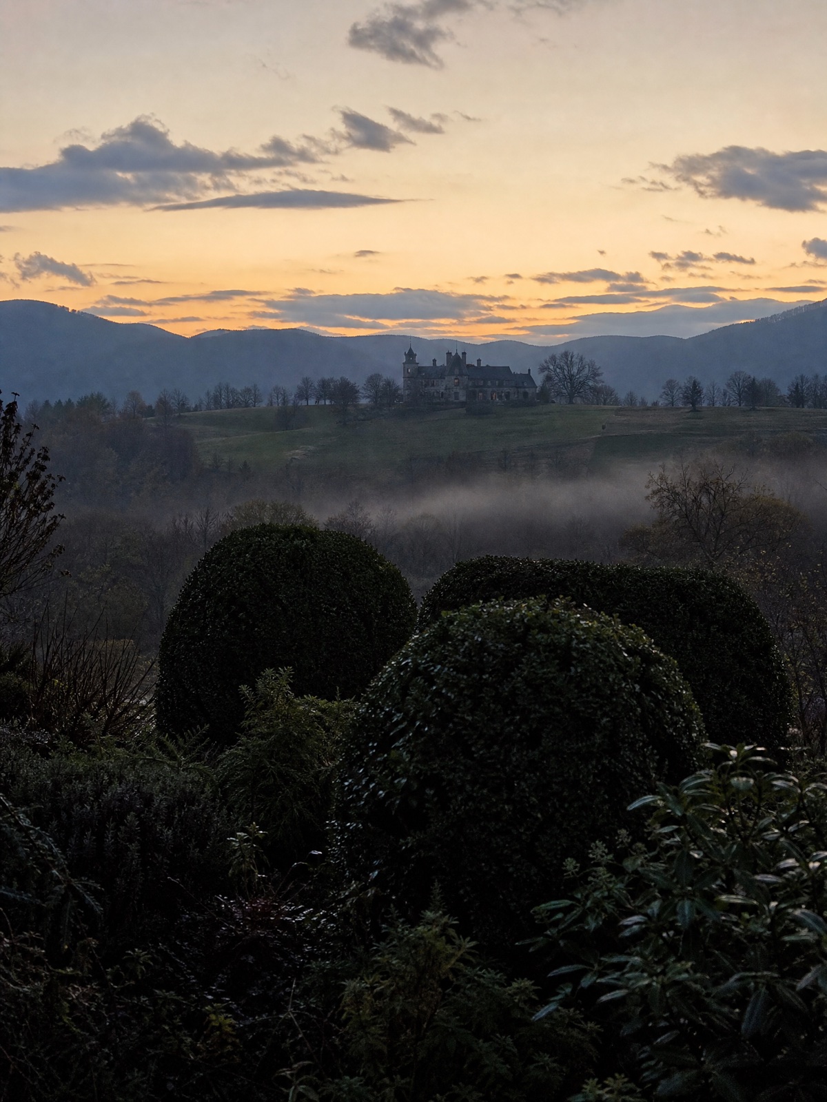 The Appalache manor at dusk with the estate landscape surrounding it.